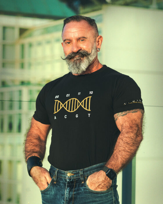 Brian Bramlett poses with a t-shirt that depicts a DNA molecule with the ACGT sequence depicted as 00 01 11 10
